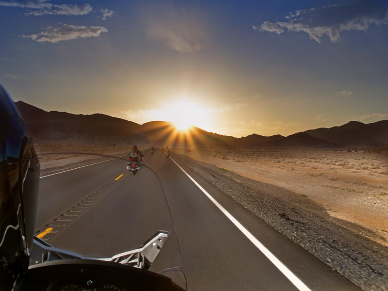 Motorcycle ride in the desert at sunset 